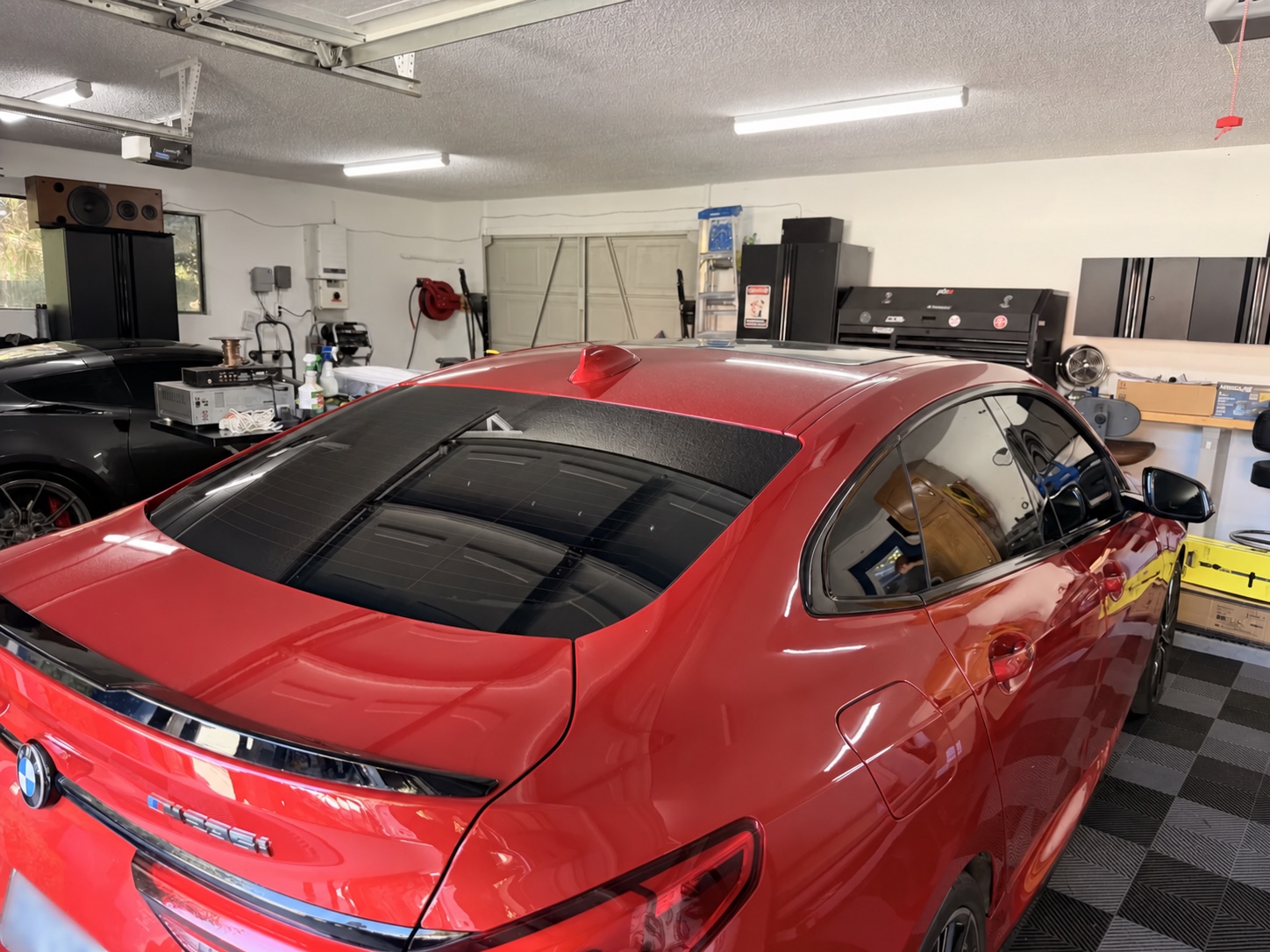 Red BMW 8 Series with premium dark window tint inside the install bay